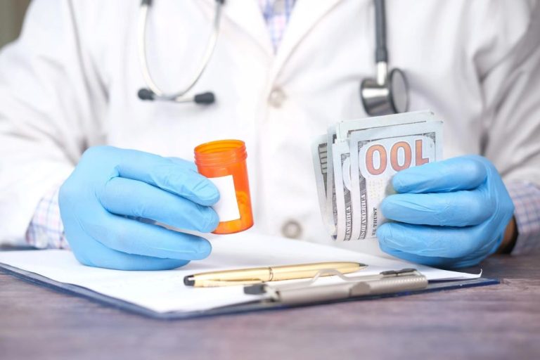 Doctor holding pill bottle and money.